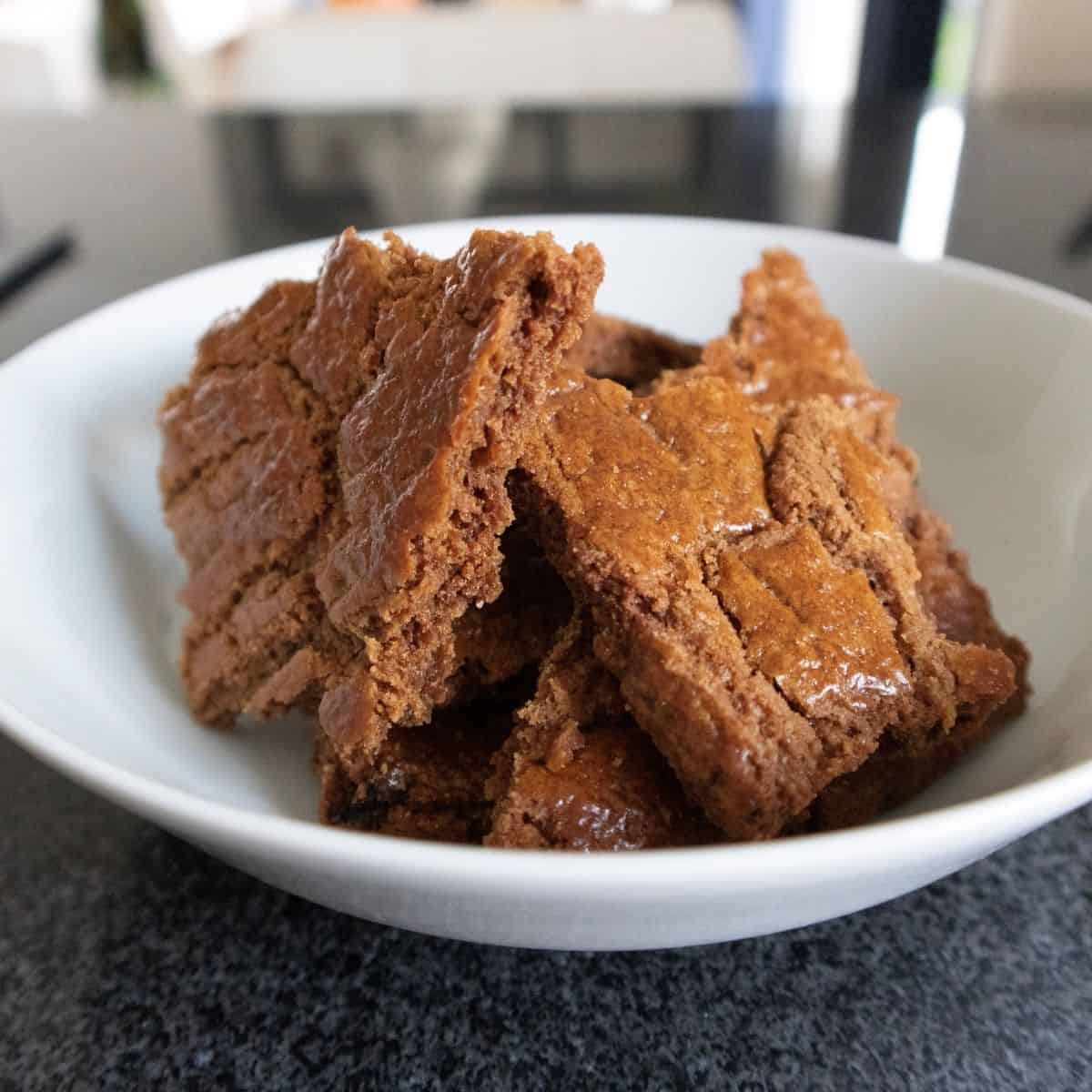 Speculaasbrokken op een wit bord.