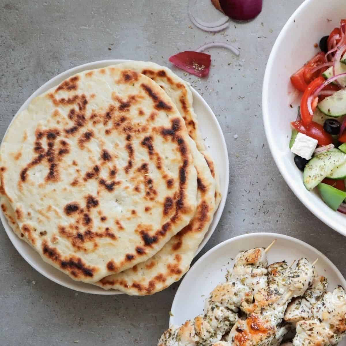 Griekse pitabroodjes met een salade en souvlaki.