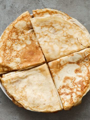 crepes op een wit bord en een grijze achtergrond opgevouwen en in een groep van 4 neergelegd