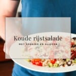 een pin om dit recept voor rijstsalade te delen op pinterest met een foto van een bord met een salade van rijst, komkommer, tomaat en olijven