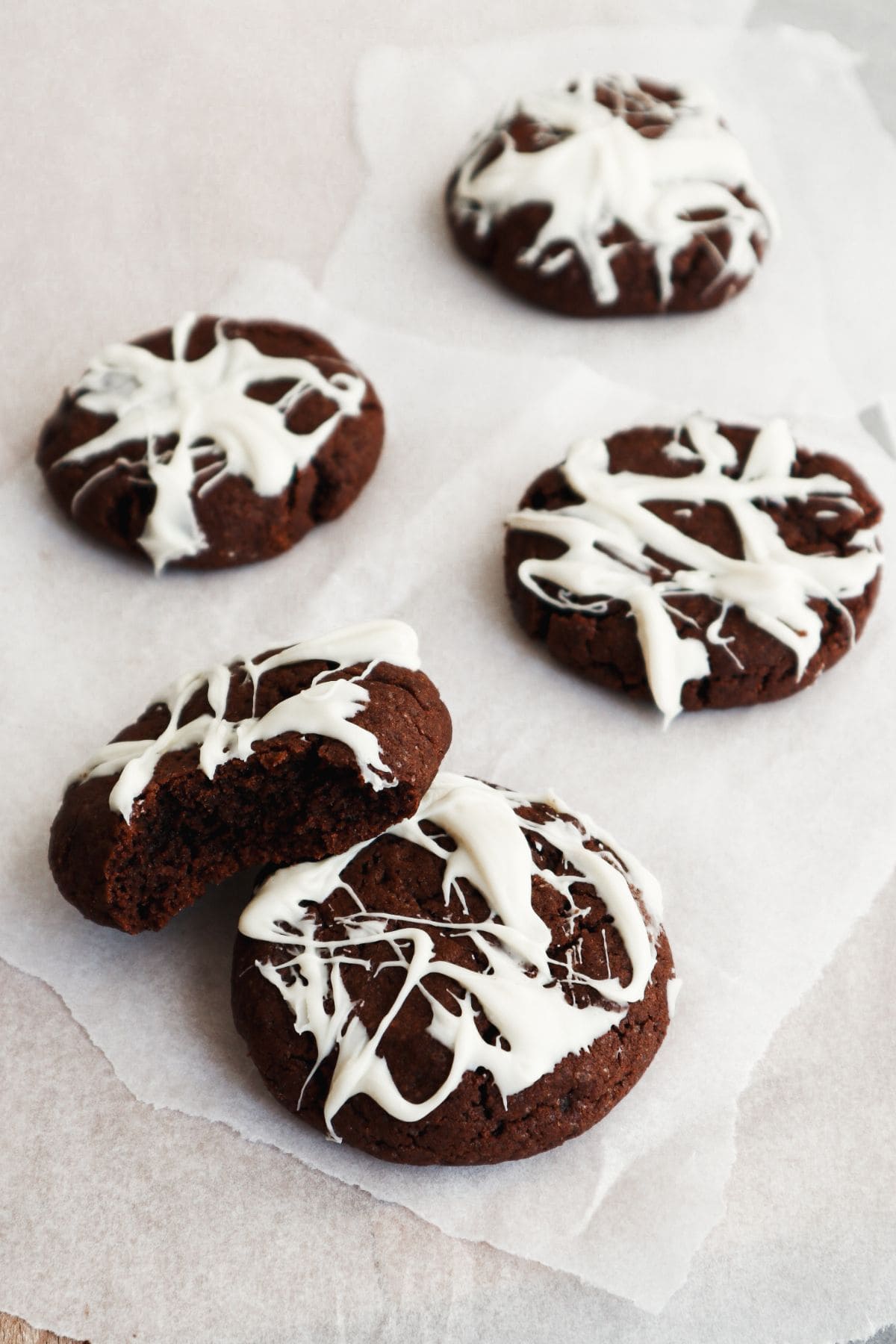 Een stapel koekjes versierd met chocolade spinnenweb.