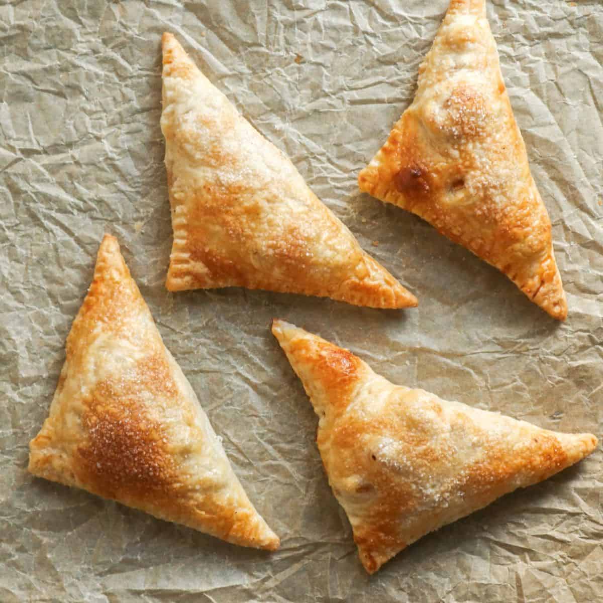 Vier appelflappen op bakpapier.